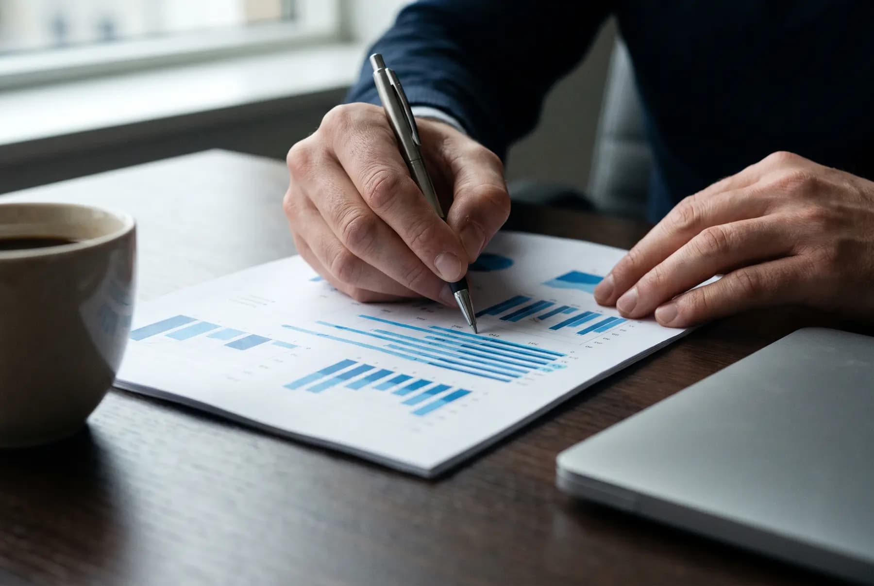 Hands reviewing a printed audit report with a pen